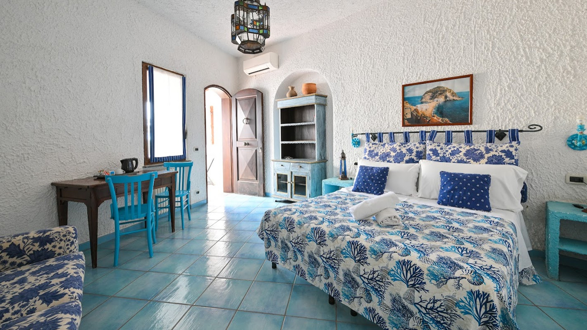 Camera con letto matrimoniale, letti a castello, specchio decorato e asciugamani.