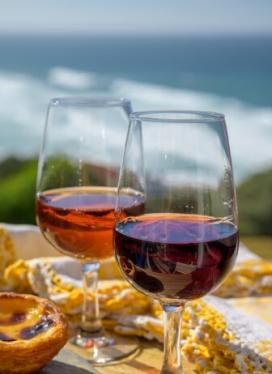 Due bicchieri di vino con vista mare e un dolce portoghese.