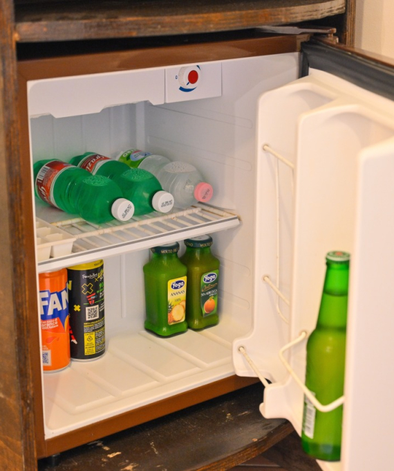 Minifrigo aperto con bevande assortite, tra cui succhi e bibite gassate.